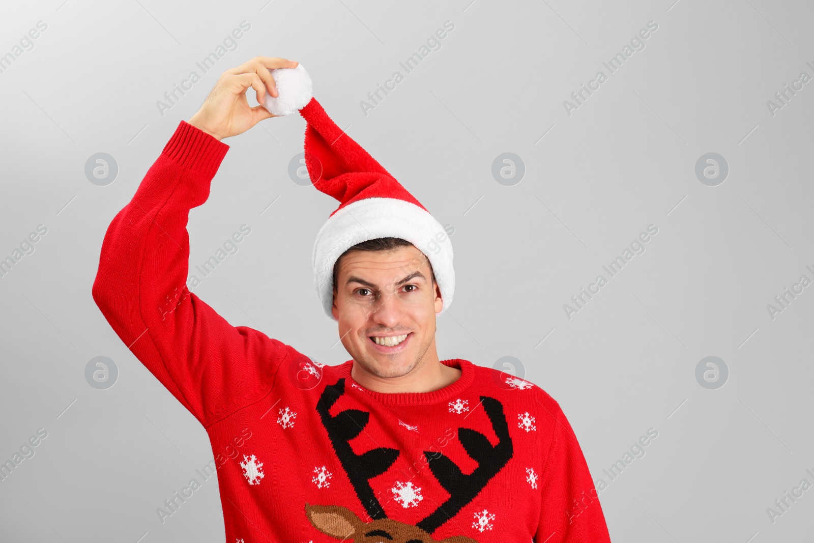 Photo of Handsome man wearing Santa hat on grey background