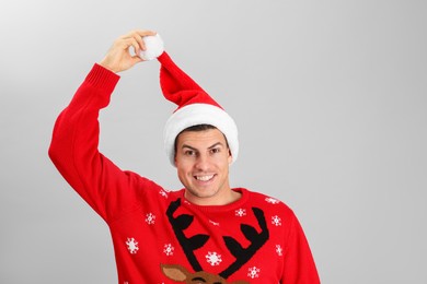Photo of Handsome man wearing Santa hat on grey background
