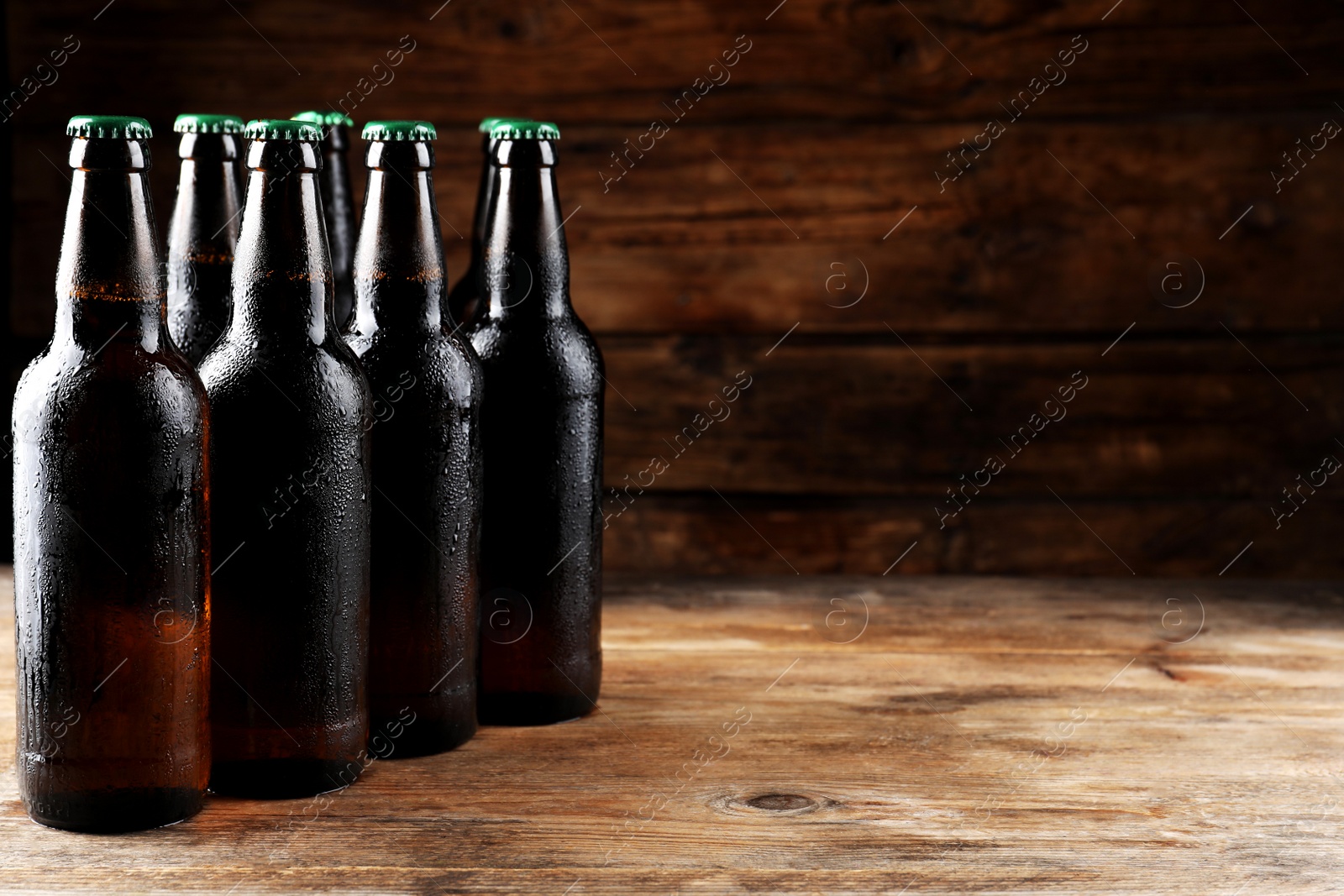 Photo of Many bottles of beer on wooden table, space for text