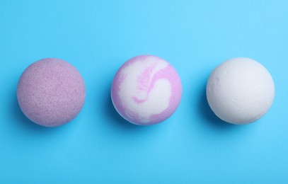 Photo of Colorful bath bombs on light blue background, flat lay