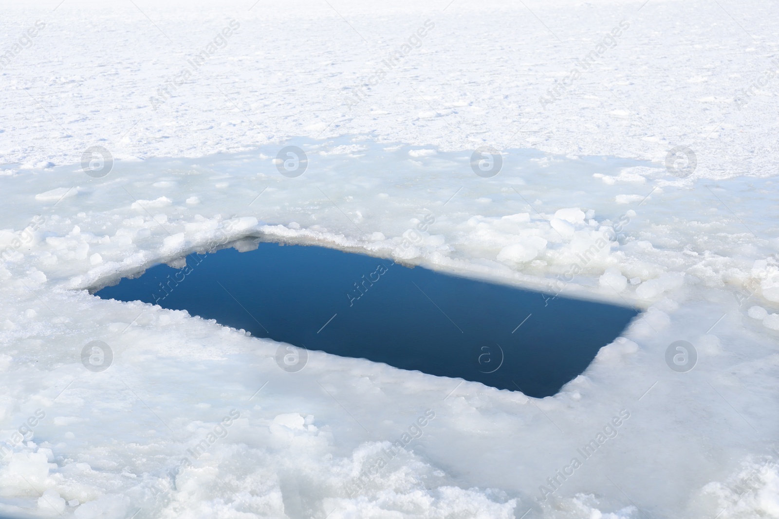 Photo of Ice hole in river on winter day. Baptism ritual