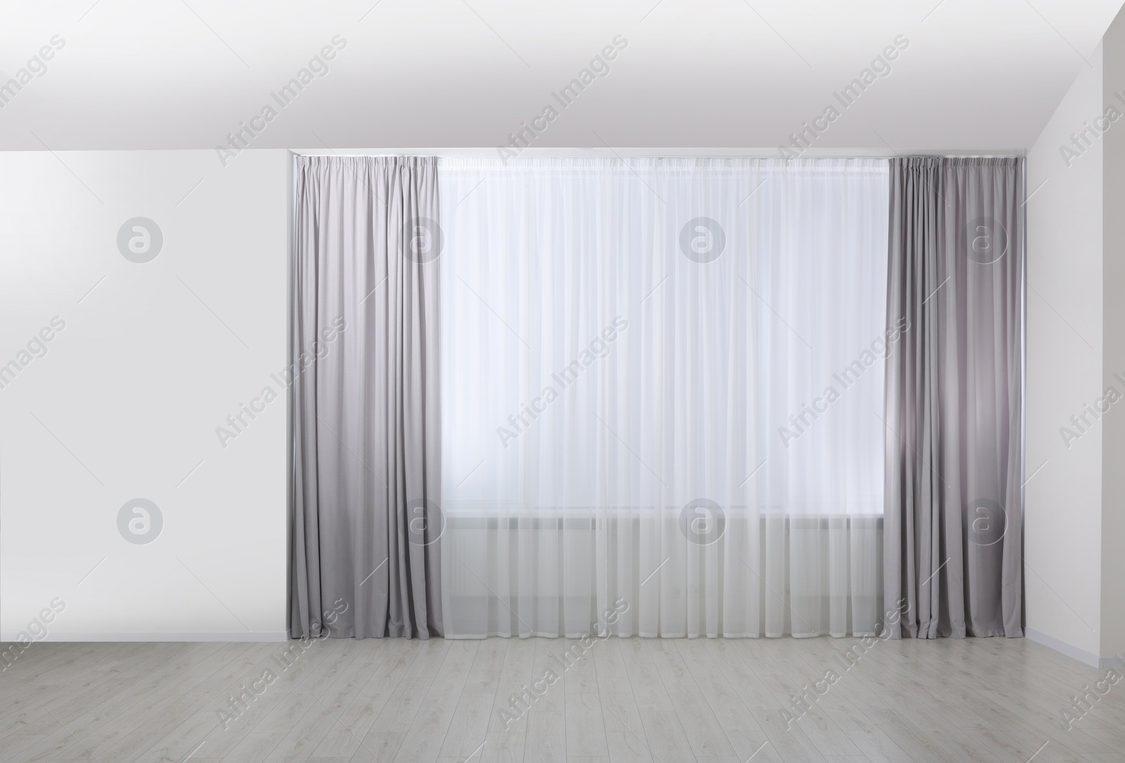 Photo of Light grey window curtains and white tulle indoors