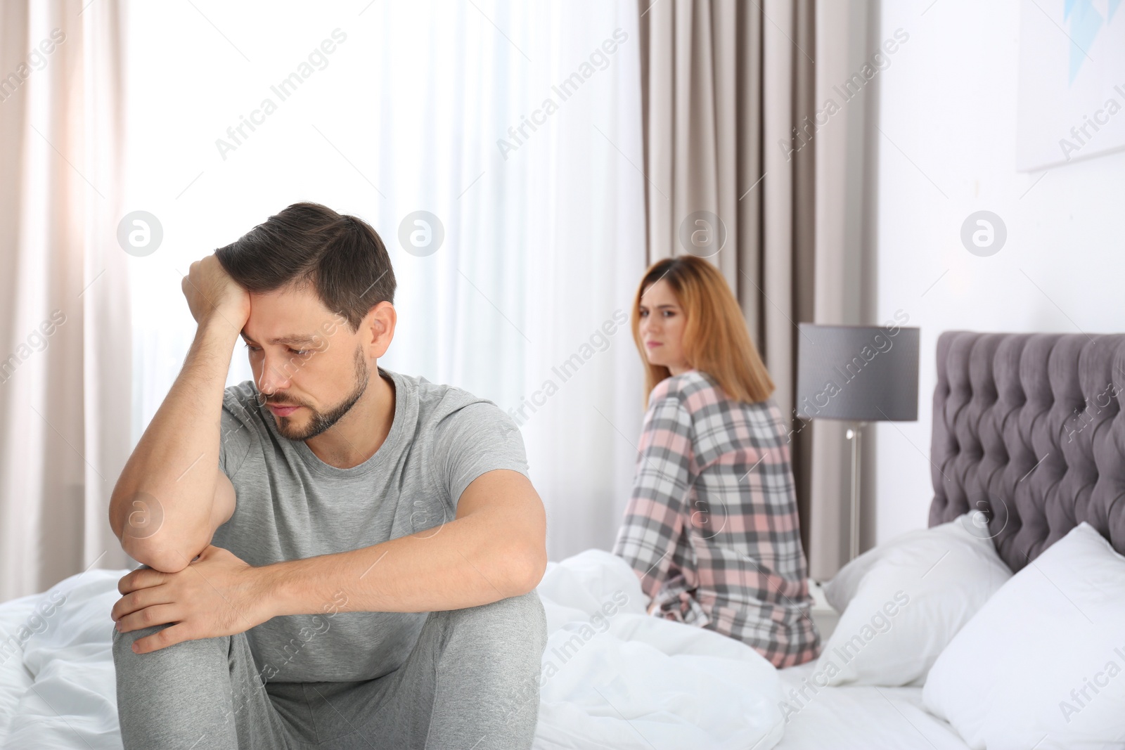 Photo of Couple with relationship problems ignoring each other in bedroom