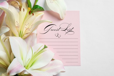 Image of Guest list and beautiful flowers on white background, closeup view