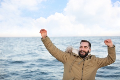 Photo of Stylish young man spending time near sea