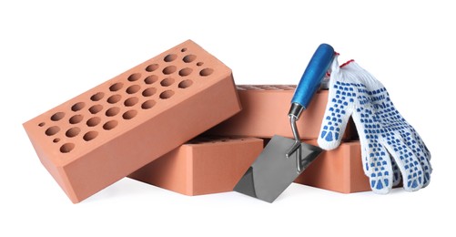 Pile of red bricks, trowel and gloves on white background