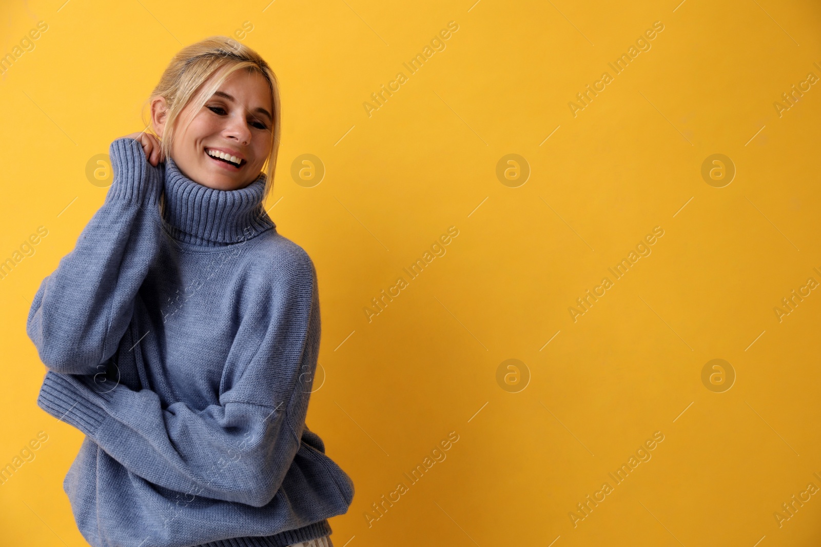 Photo of Happy woman in stylish sweater on yellow background. Space for text