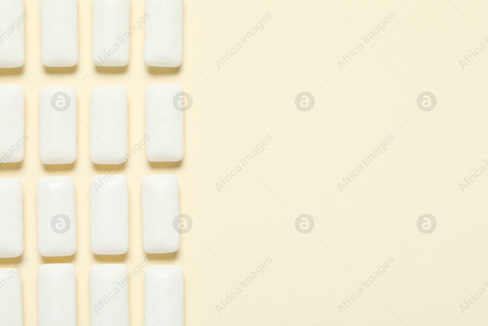 Photo of Tasty white chewing gums on beige background, flat lay. Space for text