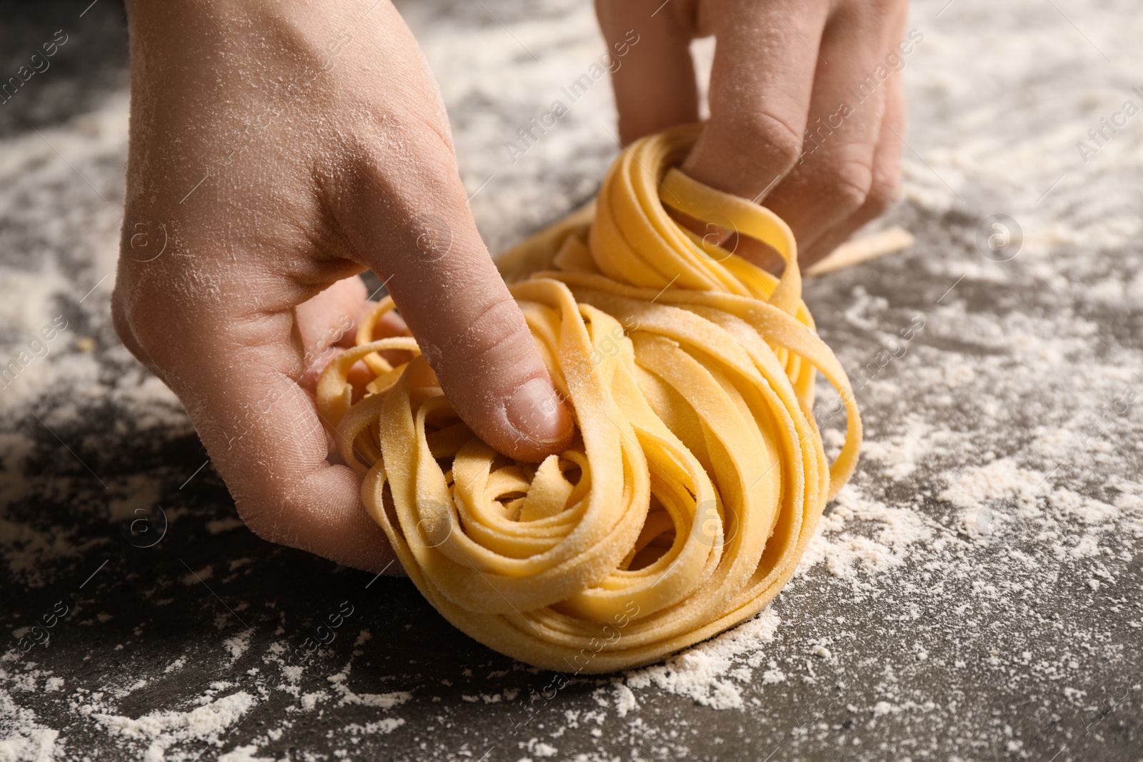 Photo of Woman holding pasta at table, closeup view