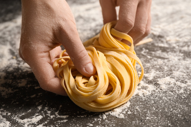 Woman holding pasta at table, closeup view