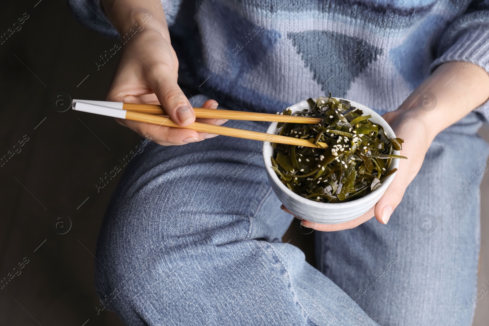 Photo of Woman eating fresh laminaria (kelp) seaweed, closeup