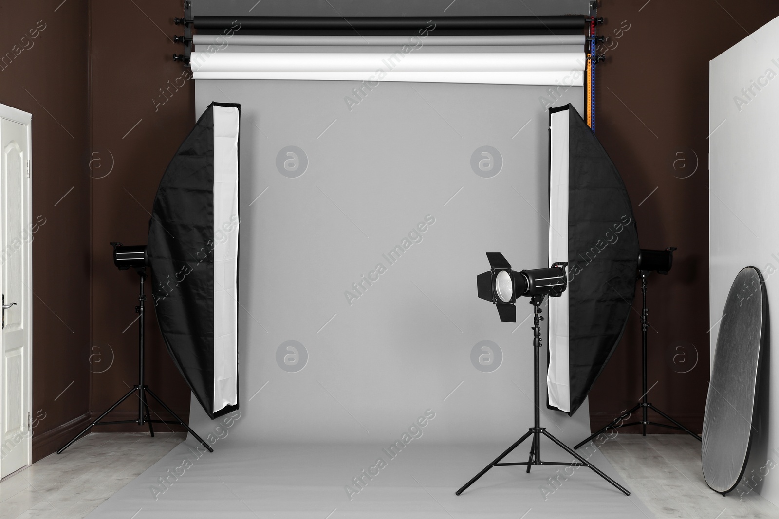 Photo of Grey photo background and professional lighting equipment in studio