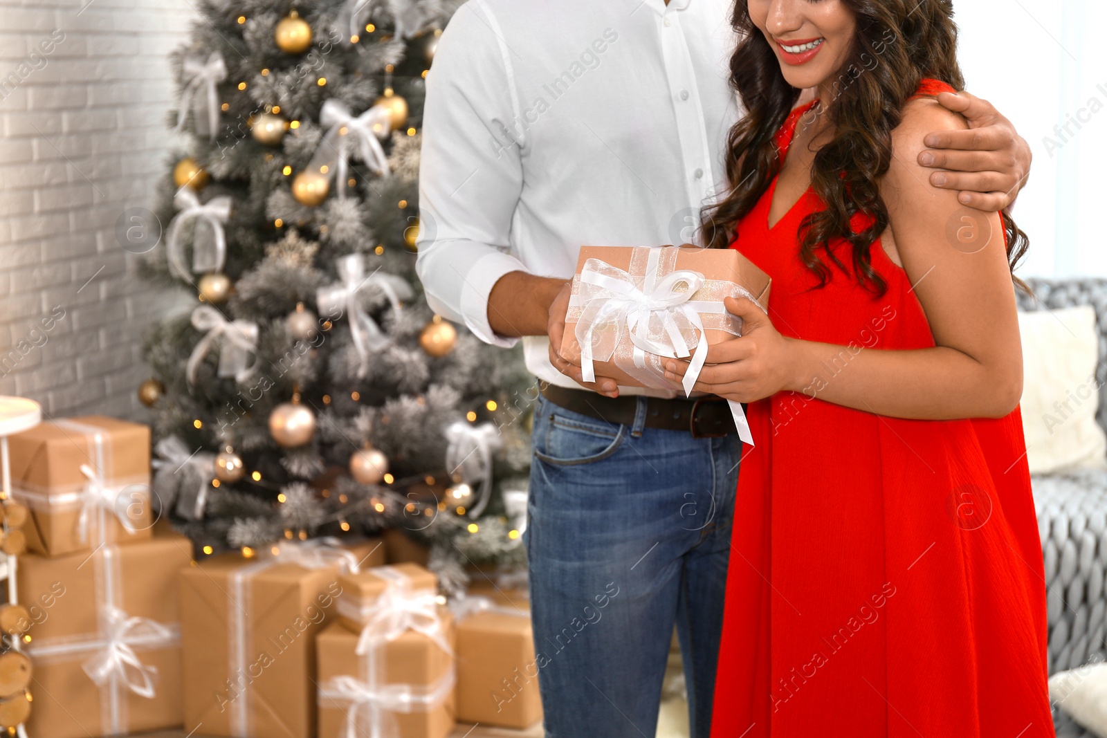 Image of Lovely couple with Christmas gift at home, closeup