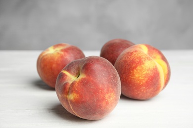 Fresh juicy peaches on white wooden table