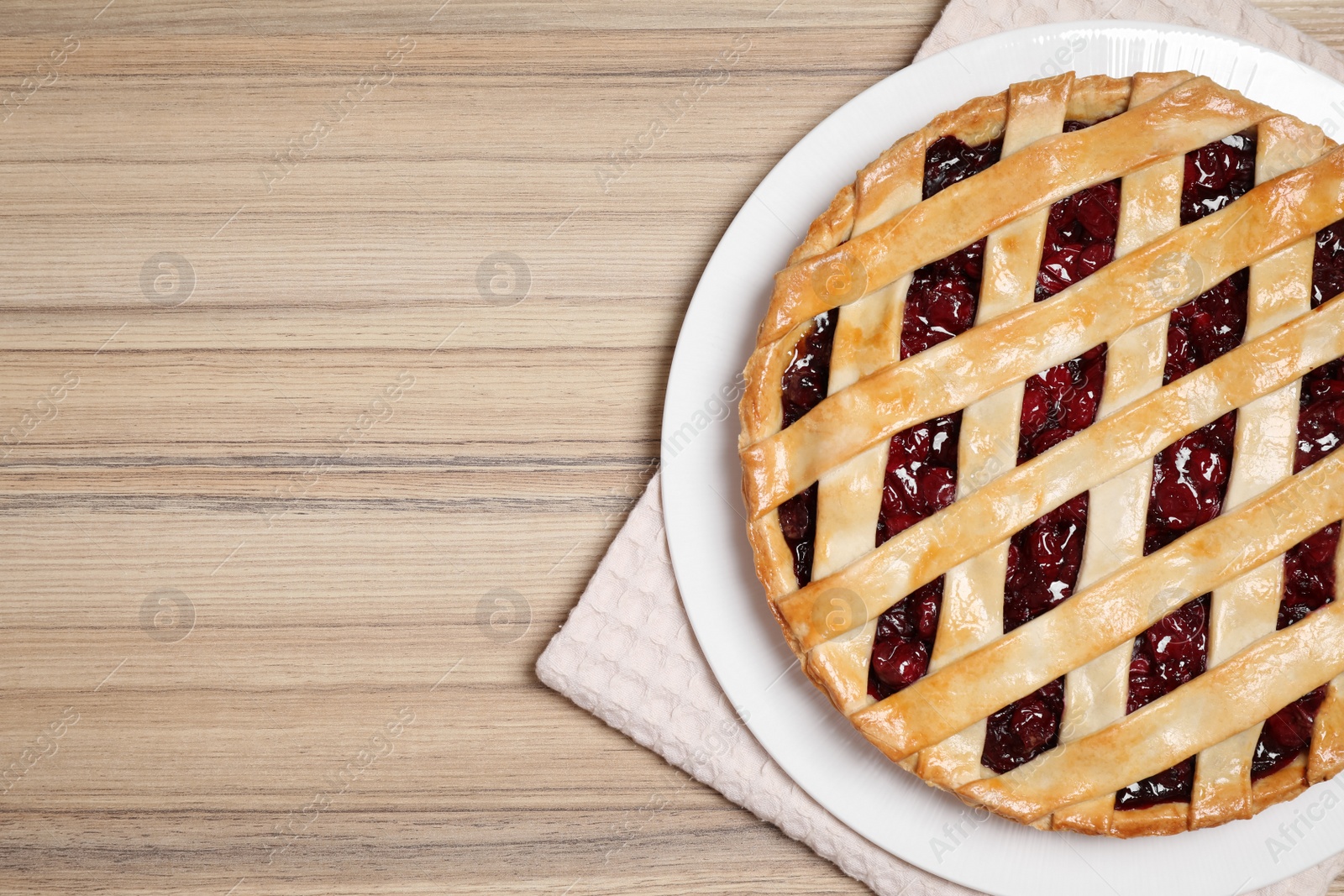 Photo of Delicious fresh cherry pie on wooden table, top view. Space for text