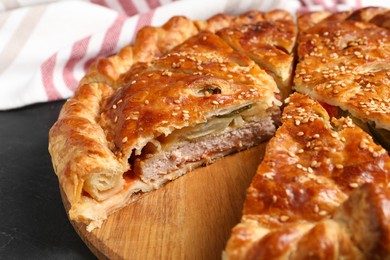 Photo of Cut delicious homemade pie on black table, closeup