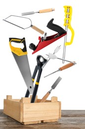 Image of Different carpenter's tools falling into wooden box on white background