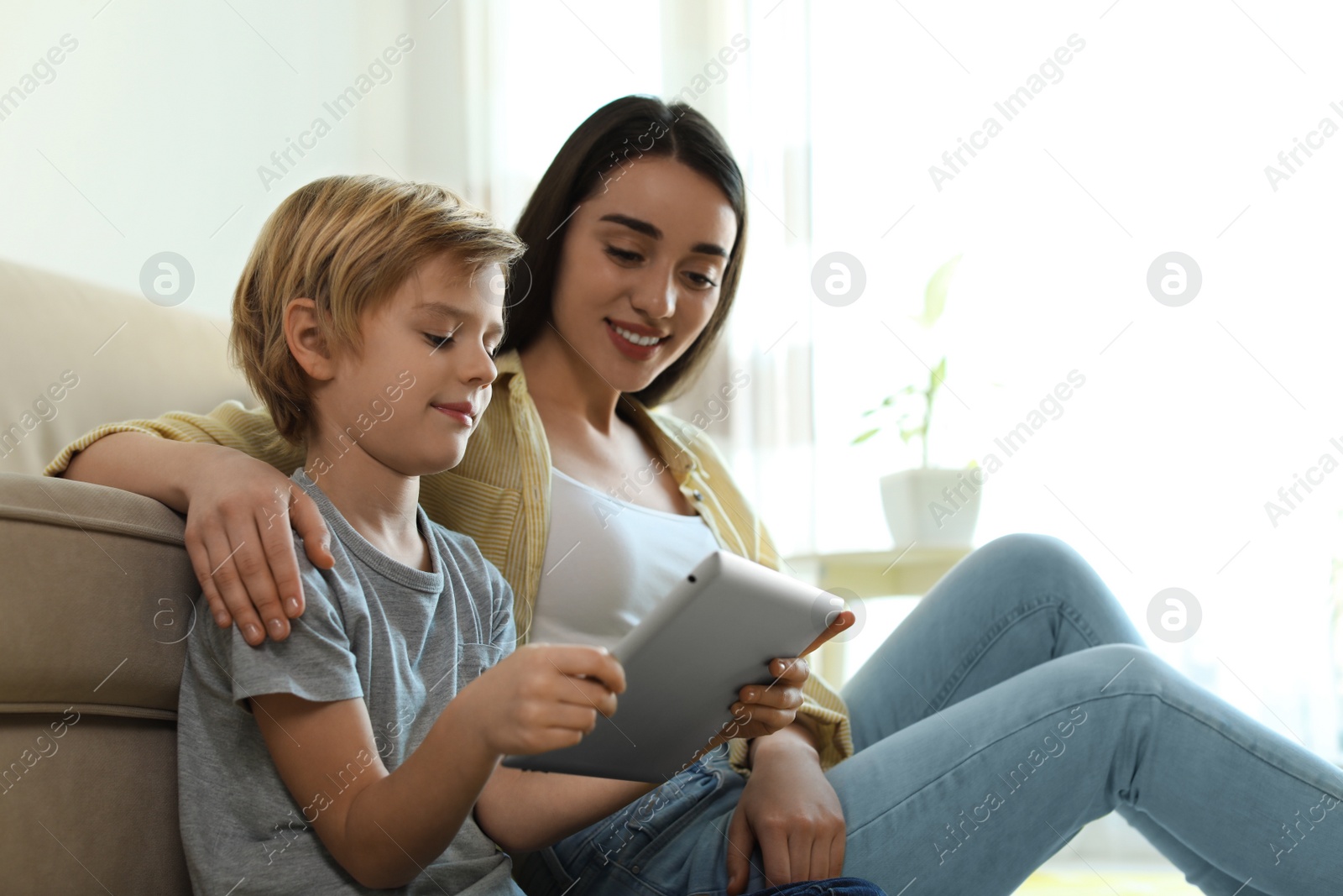 Photo of Mother and son reading E-book together at home