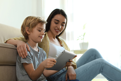 Mother and son reading E-book together at home