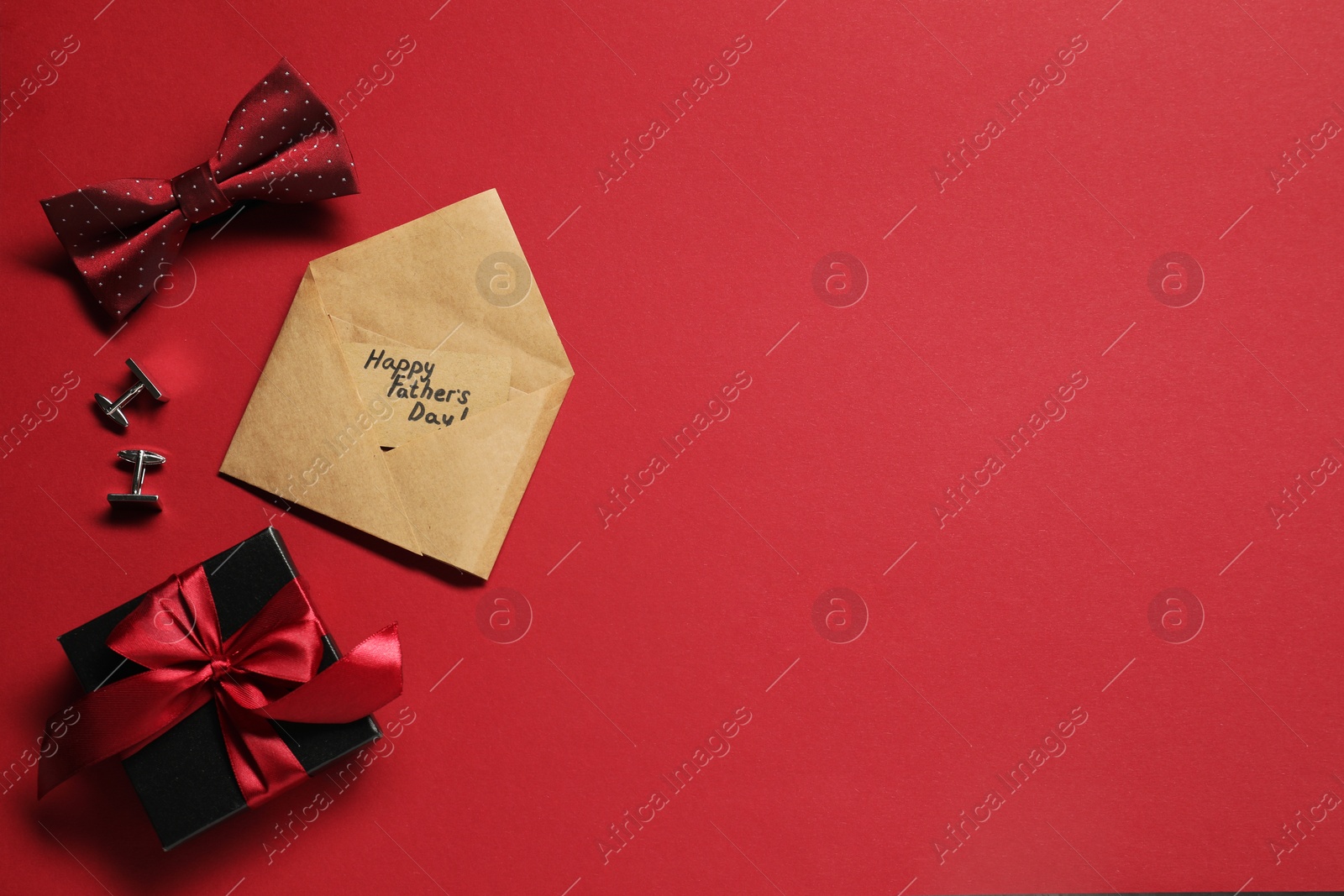 Photo of Card with phrase Happy Father's Day, gift box and men accessories on red background, flat lay. Space for text