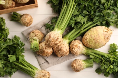 Photo of Fresh raw celery roots on white wooden table, flat lay