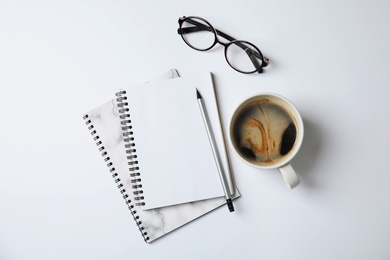 Photo of Notebooks with glasses and coffee on white background, top view