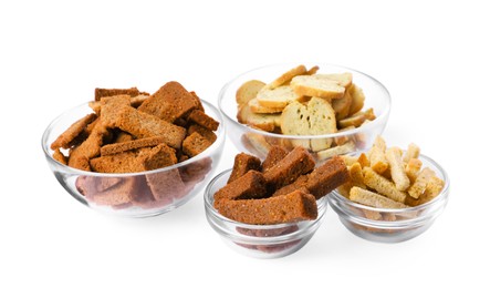 Photo of Different crispy rusks in bowls on white background