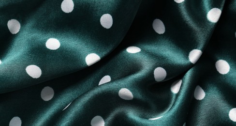 Texture of green polka dot fabric as background, top view