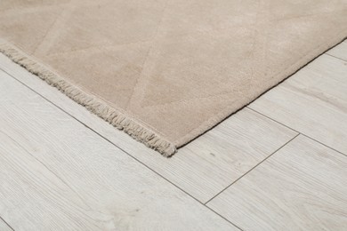 Photo of Soft beige carpet on white laminated floor indoors