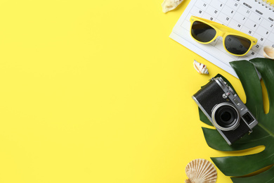 Flat lay composition with retro camera on yellow background, space for text