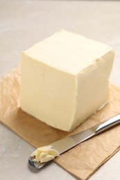 Photo of Block of tasty butter and knife on light table