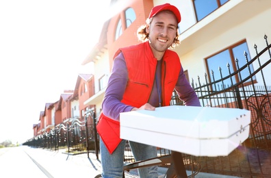 Male courier on bicycle delivering food in city