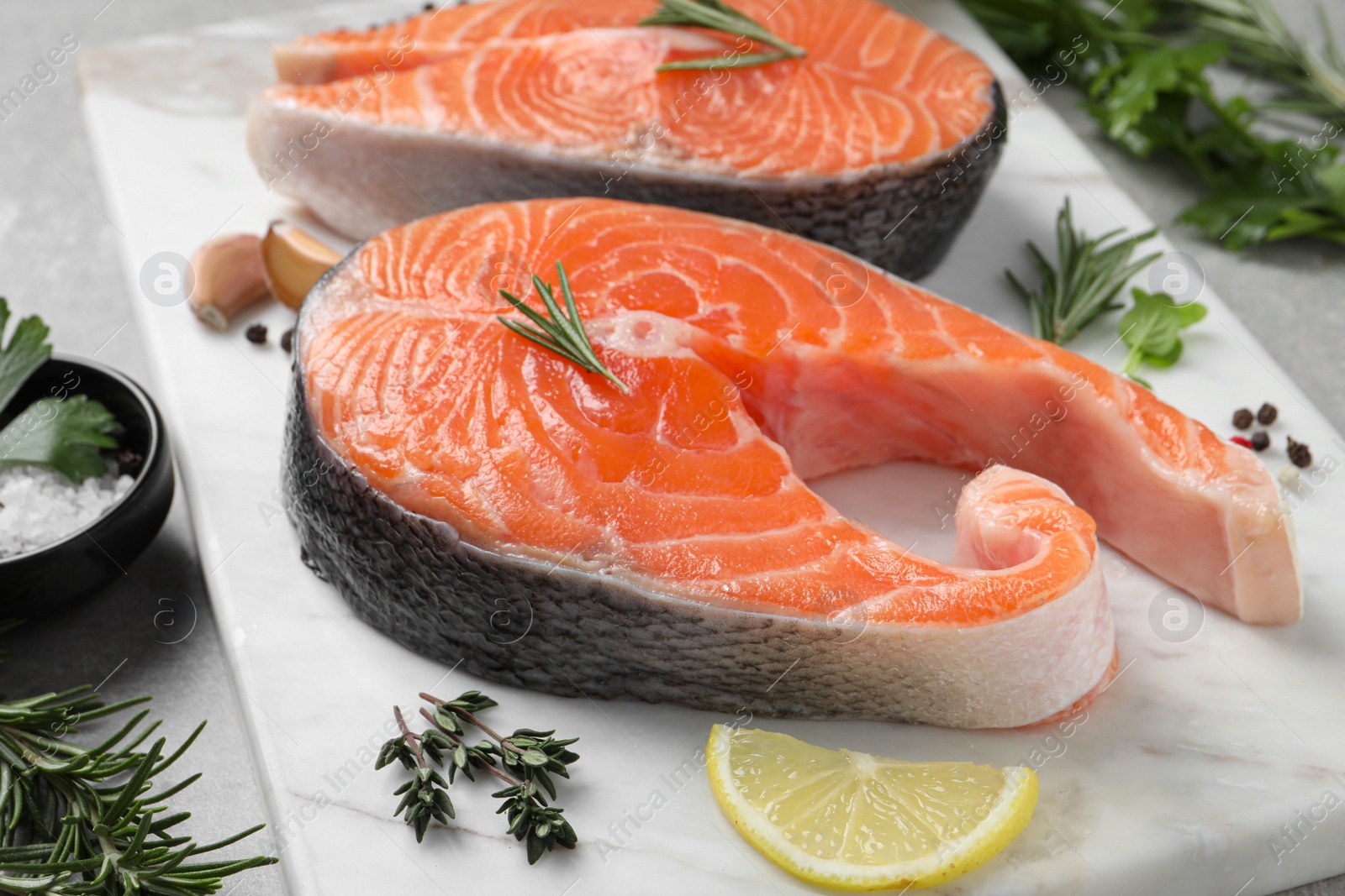 Photo of Fresh salmon and ingredients for marinade on marble board, closeup