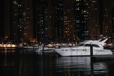 Photo of DUBAI, UNITED ARAB EMIRATES - NOVEMBER 03, 2018: Night cityscape with luxury yachts moored at pier