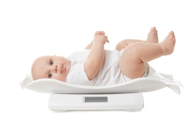 Cute little baby lying on scales against white background