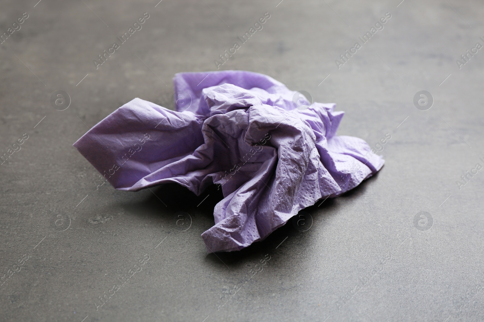 Photo of Crumpled paper napkin on grey background. Personal hygiene