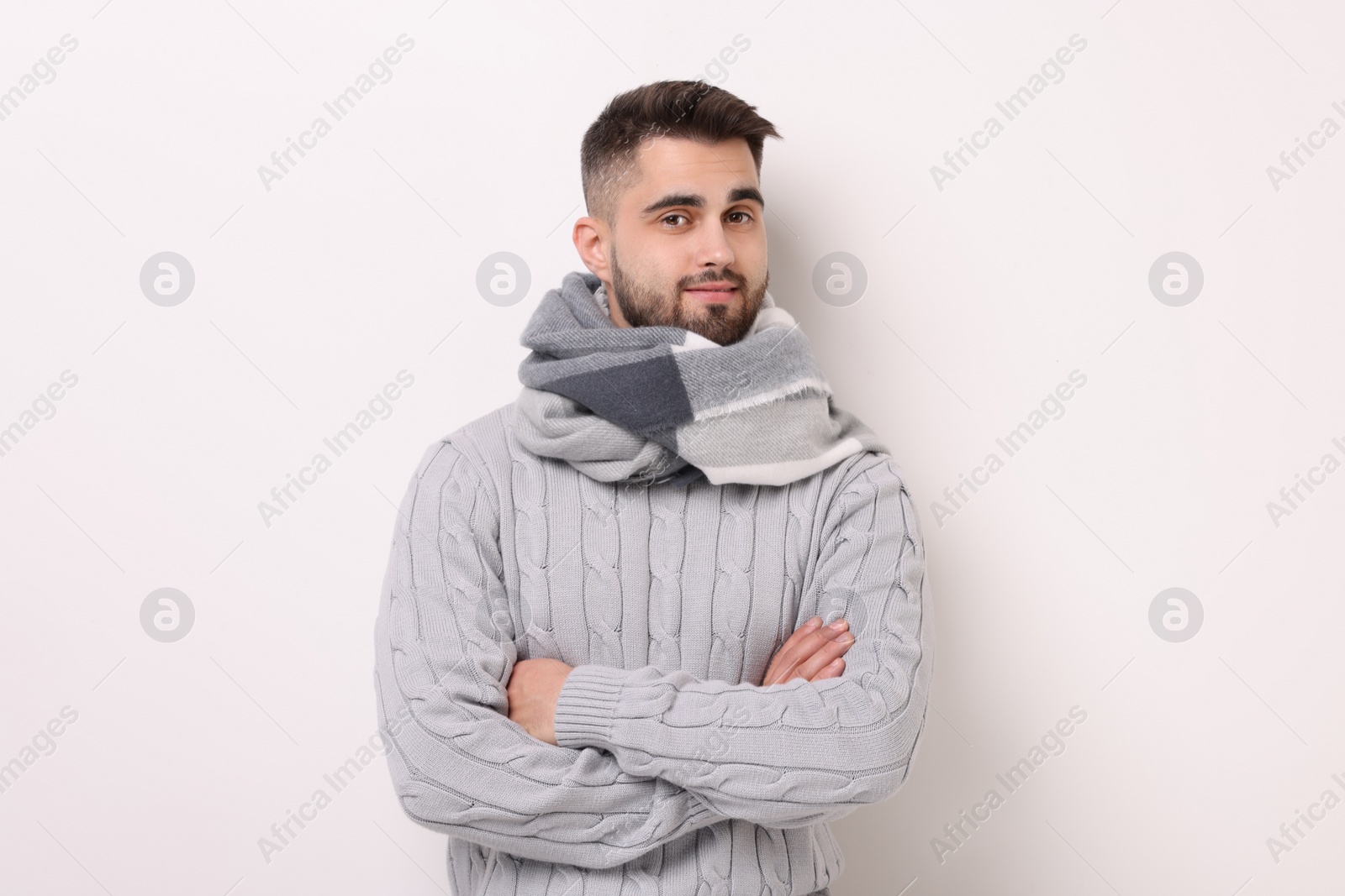 Photo of Portrait of man in warm scarf on light background