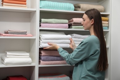 Photo of Customer choosing towels in linen shop, space for text