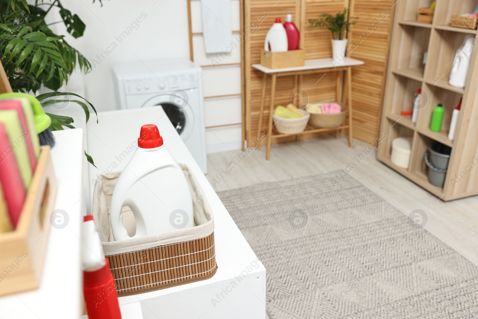 Photo of Detergent on washing machine in laundry room, space for text