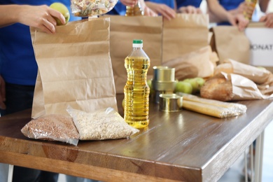 Photo of Team of volunteers collecting food donations at table, closeup