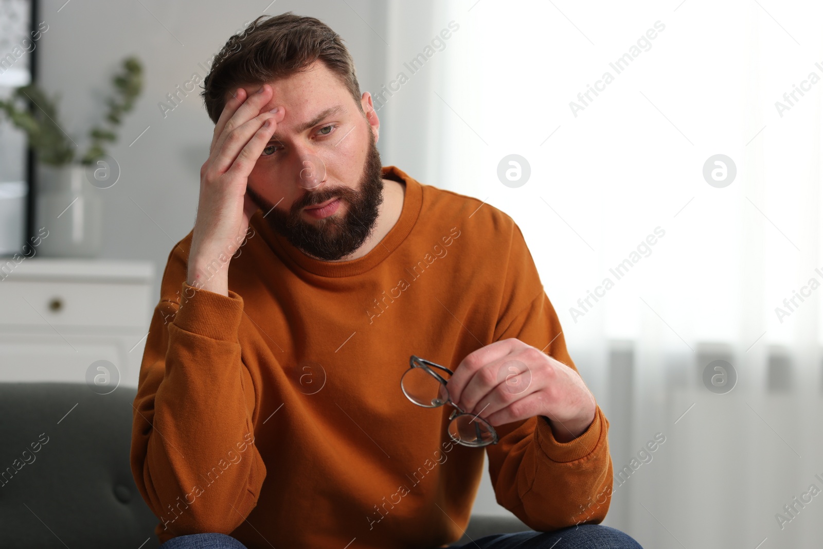 Photo of Overwhelmed man with glasses suffering at home