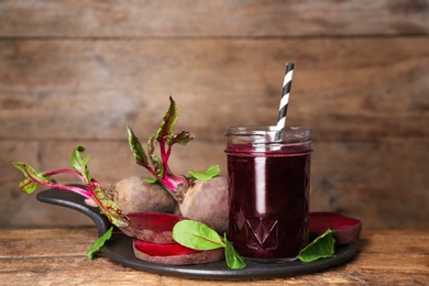 Photo of Freshly made beet juice on wooden table