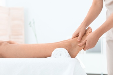 Photo of Woman receiving foot massage in wellness center, closeup