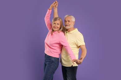 Photo of Senior couple dancing together on purple background