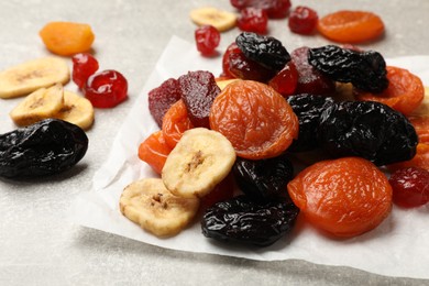 Photo of Mix of delicious dried fruits on grey table, closeup