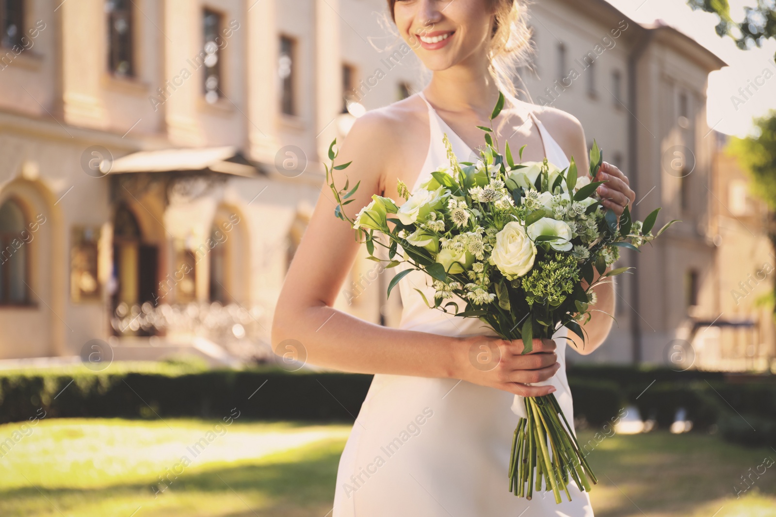 Photo of Bride in beautiful wedding dress with bouquet outdoors, closeup