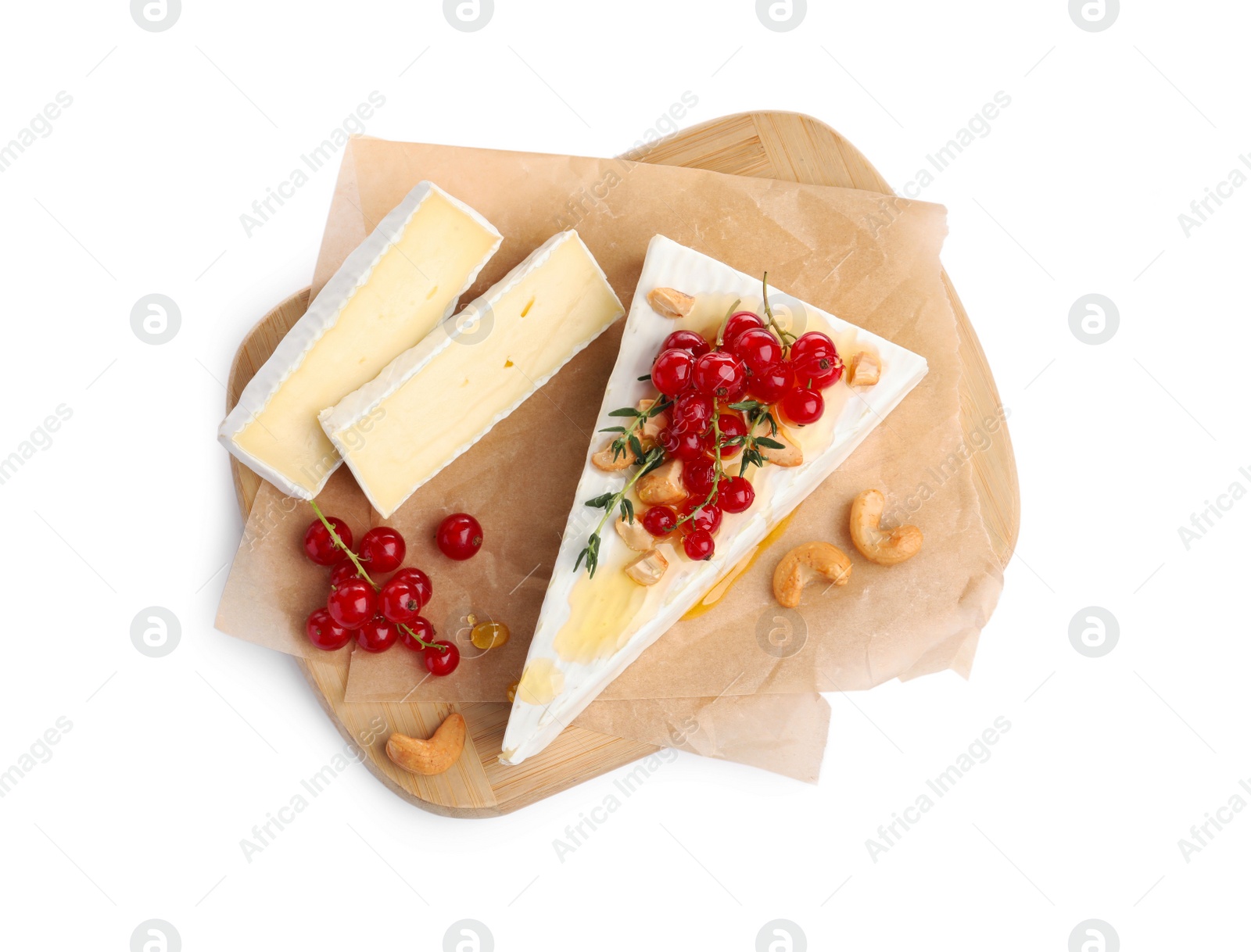 Photo of Brie cheese served with red currants, nuts and honey isolated on white, top view