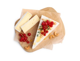Photo of Brie cheese served with red currants, nuts and honey isolated on white, top view