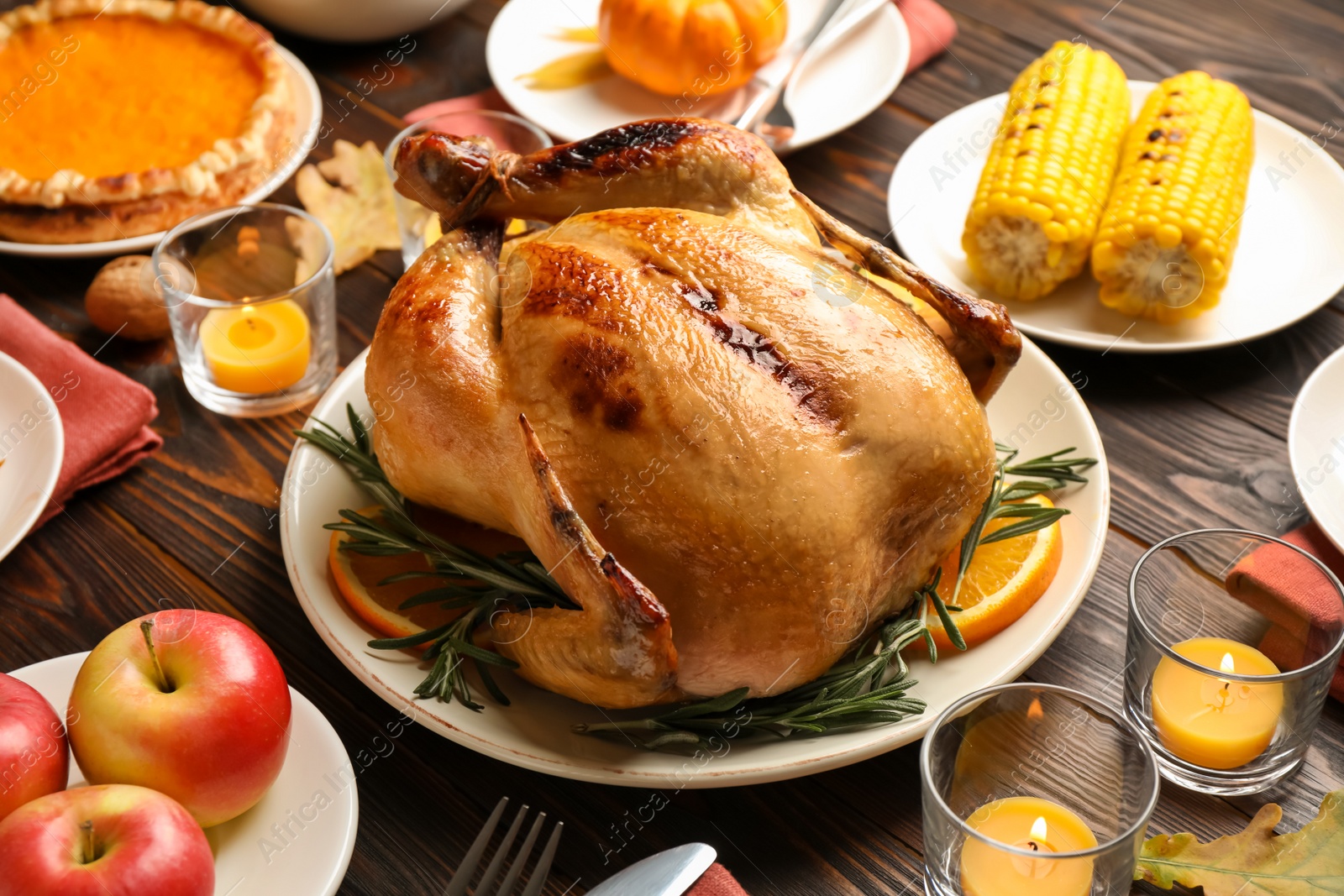 Photo of Traditional Thanksgiving day feast with delicious cooked turkey and other seasonal dishes served on wooden table