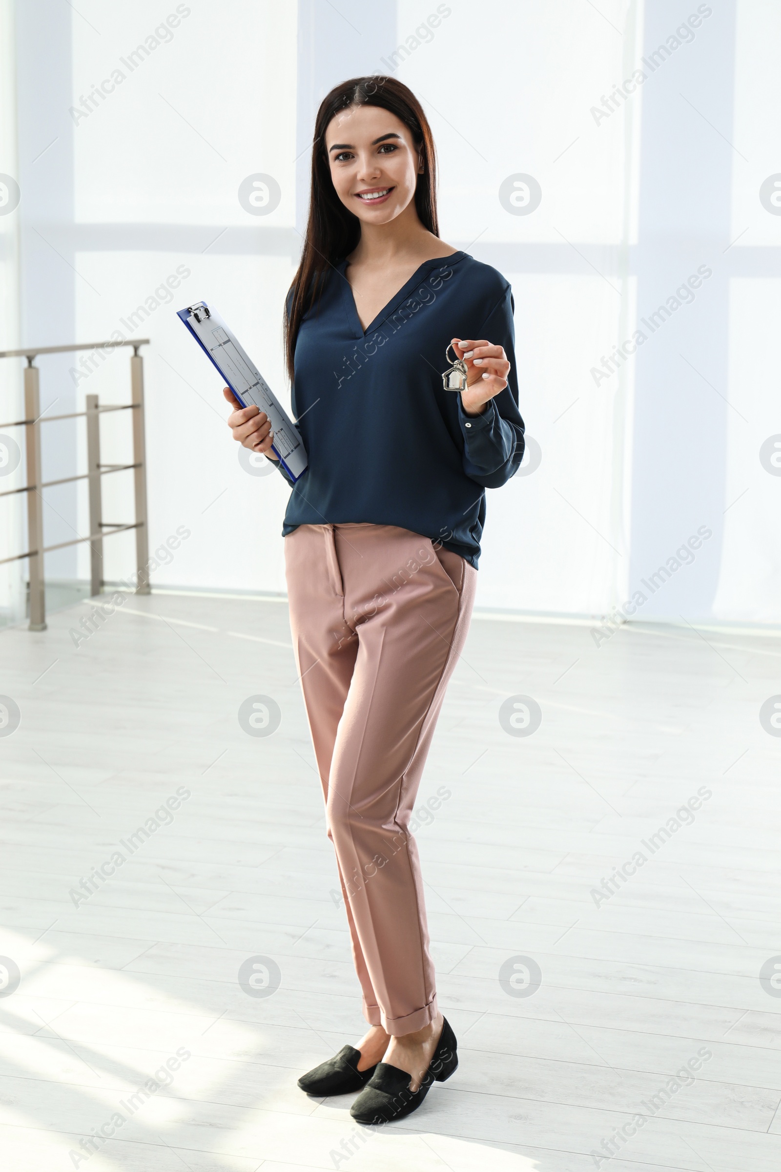 Photo of Female real estate agent holding key in new apartment